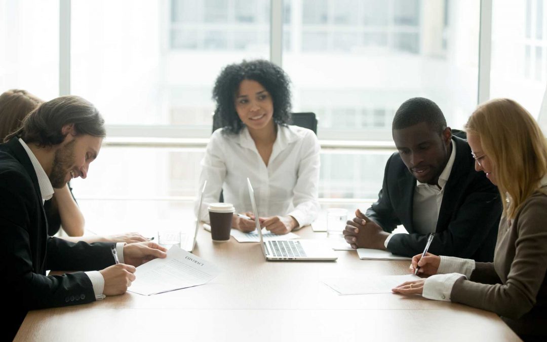 A group of executives work together at a conference table.