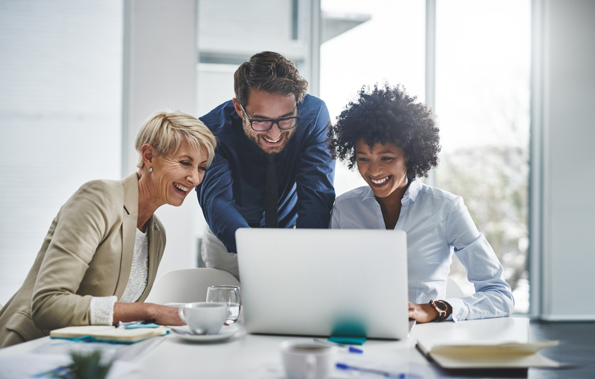 People gathered around a laptop in an office